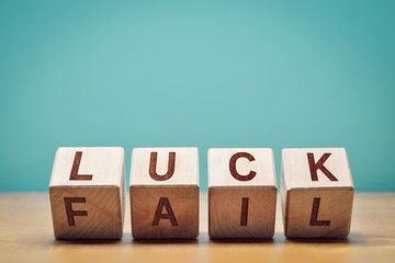 Wooden cubes with letters forming the words "luck" and "fail" with copy space: concept of strategy and attitude towards success and self-development