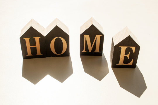 Inscription from wooden cubes home with contrasting shadows on a white background. Coronavirus epidemic - Powered by Adobe