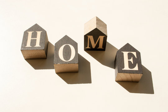 Inscription from wooden cubes home with contrasting shadows on a white background. Quarantine concept. Coronavirus epidemic