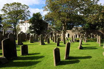 Fototapeta na wymiar Kirkwall - Orkney (Scotland), UK - August 07, 2018: 12th century Romanesque Saint Magnus cathedral cemetery in Kirkwall, Orkney, Scotland, Highlands, United Kingdom