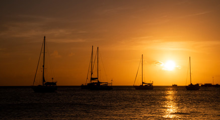 Fototapeta na wymiar Few yachts in the sea at bright sunset.