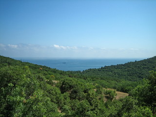 Obraz premium Sea view from the coastal mountains. The coastal hills are surrounded by dense vegetation.