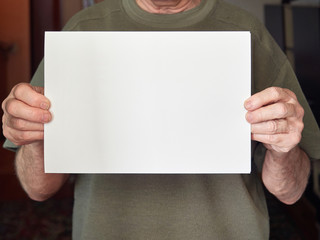 Obraz premium the hands of an old man hold a white sheet without text. coronavirus, covid-19.