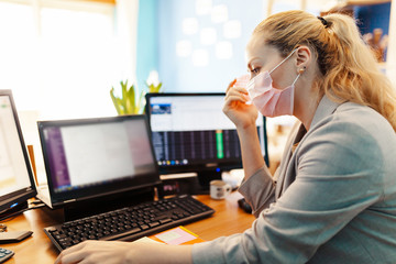 Woman wearing surgical mask with covid 19 model in her hand