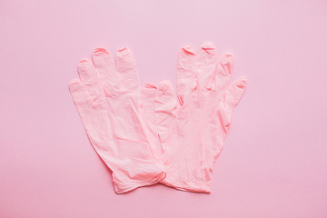 Pink gloves on pink background flat lay. Coronavirus pandemic. Stay safe. Prevention of virus epidemic. Safe shopping and walking outside in quarantine. Medical gloves