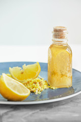 Yellow juicy Lemon, shredded Ginger and Honey on blue plate for homeopathic mixture to treat flu virus symptoms on white background