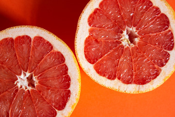 Sliced ​​grapefruit on a orange background