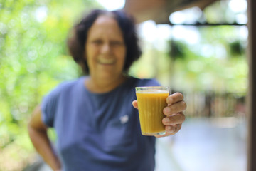 idosa feliz prestes a ingerir suco nutritivo para manter a imunidade alta