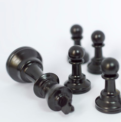 Black chess with white background. Focused at black pawn.