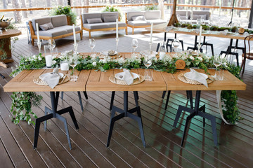Festive wedding table setting with flowers, napkins, cutlery, glasses and candles, bright summer table decor. Wedding decor