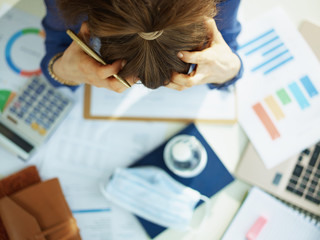 Upper view of stressed middle age business woman at table