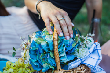 girl's hand holding a basket full of flowers