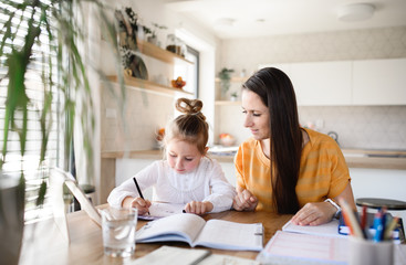 Mother and daughter learning indoors at home, Corona virus and quarantine concept.