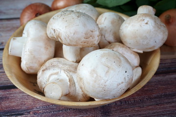 Mushrooms, spinach and onions on a wooden table