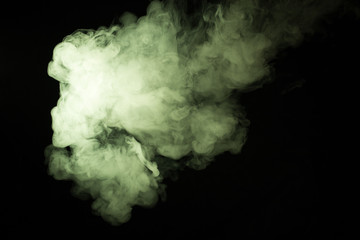 Colorful smoke close-up on a black background. Yellow cloud of smoke.
