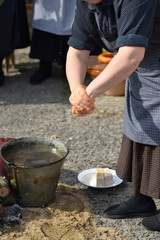 woman washing her hands in water heated on fire