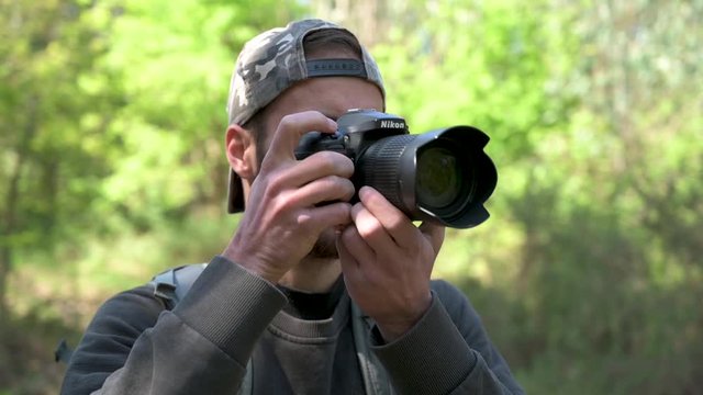 Photographer taking photos in nature. Slow motion.