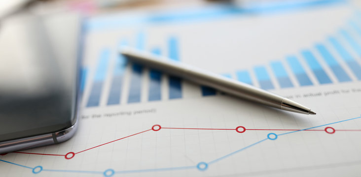 On Table Is Report With Graph And Silver Pen. Preliminary Analysis Target Audience. Feature Calculating Interest On Loan Or Deposit. Increasing Sales, Opening Branches, Creating Franchise