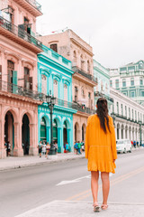 Obraz premium Tourist girl in popular area in Havana, Cuba. Back view of young woman traveler