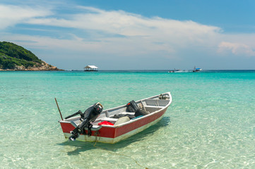 Fototapeta na wymiar Boat with clear water and blue skies at Perhentian Island, Malaysia