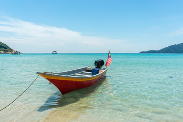 Naklejka na ściany i meble Boat with clear water and blue skies at Perhentian Island, Malaysia