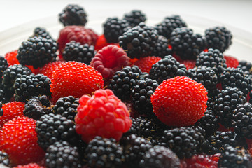 The berries of red and black raspberries are delicious and beautiful.