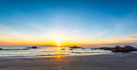 Obraz na płótnie Canvas Beach wave with orange sunrise background