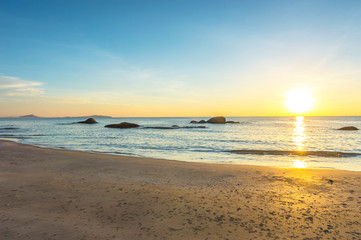 Fototapeta na wymiar Beach wave with orange sunrise background