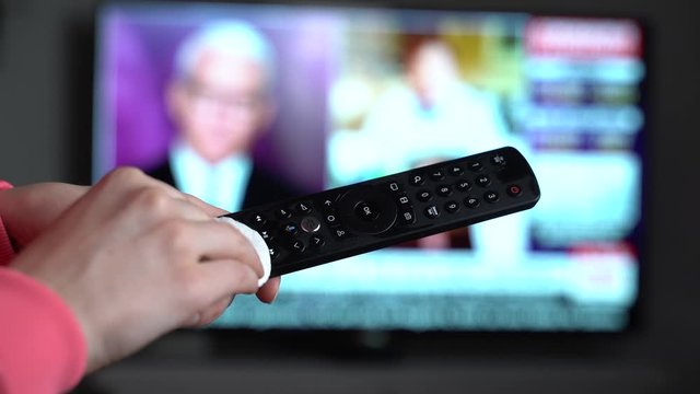 Disinfecting television remote control with alcohol and cotton pad Close up female hand disinfection