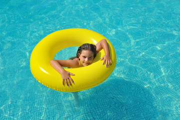 Real adorable girl relaxing in swimming pool