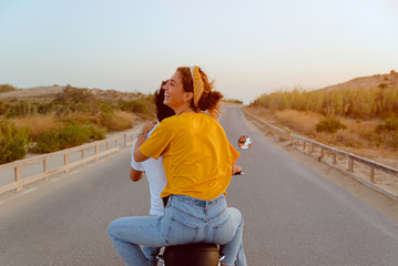 young couple on motorcycle on a road traveling to the beach