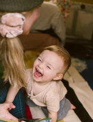 mother and baby daughter playing together on the floor at home