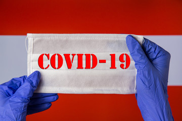 Coronavirus outbreak. Coronavirus update in Austria. Word Covid-19 on medical mask with austrian flag on background. Spread of corona virus in world. Wuhan virus. Stay at home during quarantine.
