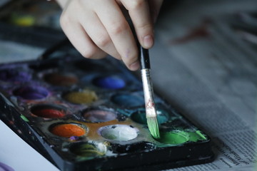 Farbkasten mit Kinder Hand, Wasserfarben und Farbpinsel