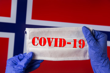 Coronavirus outbreak. Coronavirus update in Norway. Word Covid-19 on medical mask with flag of Norway on background. Spread of corona virus in world. Wuhan virus. 