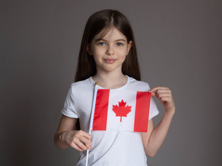 Little girl with canadian flag on a white background. Study, immigration to Canada