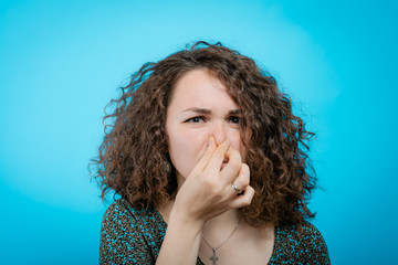 The stench. Closes the woman's nose