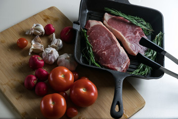 Fresh cuts of beef. Steak in the pan. Meat and vegetables. Marble beef.