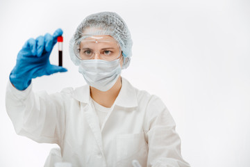 female scientist in uniform holding tube of blood with coronavirus in clinic