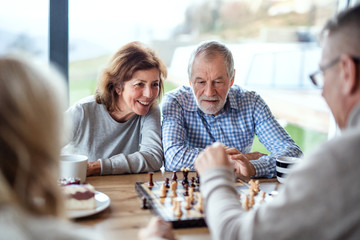 Group of senior friends at home, playing board games.