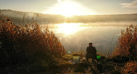 Amateur angler is fishing on autumn in the lake © photoidea