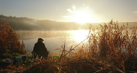 Amateur angler is fishing on autumn in the lake © photoidea