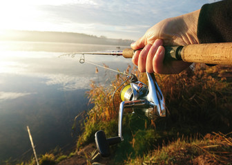 Amateur angler is fishing on autumn in the lake - obrazy, fototapety, plakaty