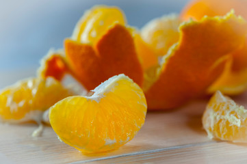 bright juicy slice of tangerine. orange tangerine close-up. a slice of ripe tangerine on a white wood surface
