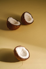 Coconut fruits on cream yellow plain background, abstract food tropical concept, angle view copy...