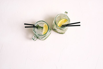 Two glass glasses with mojito summer cocktail. Refreshing alcoholic cocktail on a white background.