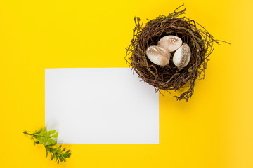 Naklejka na ściany i meble Decorted Easter eggs in a bird's nest on a yellow background