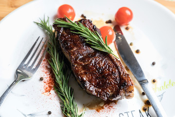 roast beef fillet steak meat with rosemary on a white plate. Juicy piece of meat. Delicious dinner.