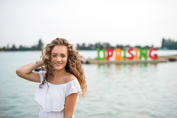 Fototapeta na wymiar Young woman at summer festival, standing in lake.