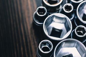 A studio photo of a socket wrench on a dark raw wooden background - garage tools, mechanic,...